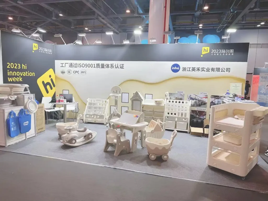 B2B visitors and professional buyers gathering around to examine high-end preschool activity tables and minimalist children's chairs at the Inhe trade show booth.