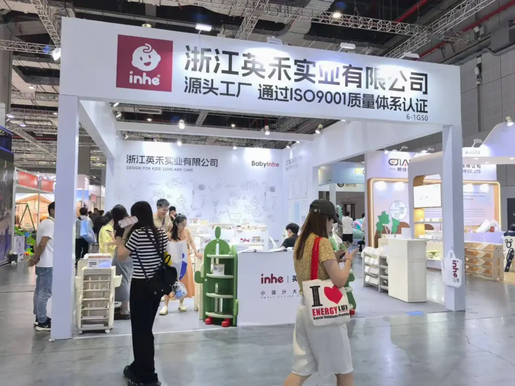 The exterior of the Inhekids trade show booth (6-1G50) with international visitors and B2B buyers browsing products during CBME Shanghai 2025.