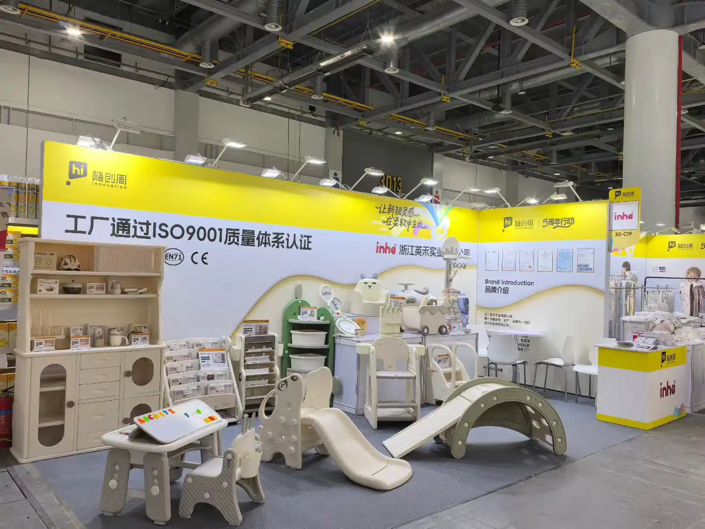 A wide shot of Inhekids trade show booth featuring high-end children's indoor climbing frames, wooden slides, feeding cabinets, and activity furniture.