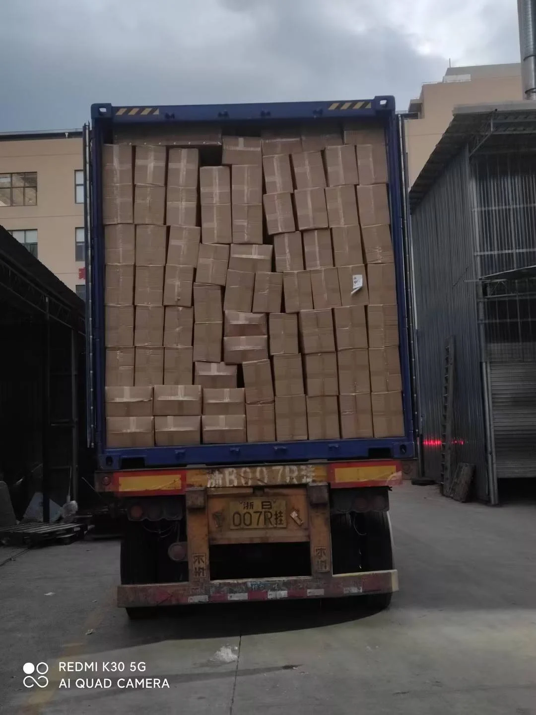 Cardboard cartons stacked inside a shipping container at the inhekids factory.