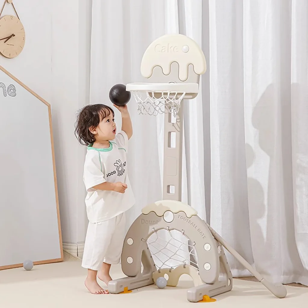 A toddler playing with a cream cake theme indoor basketball stand in a minimalist modern playroom from wholesale supplier.